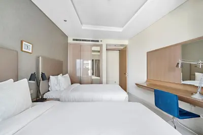 a hotel room with two beds and a desk at ALiving Luxury 2BR I Paramount Towers, Business Bay- 6106 in Dubai
