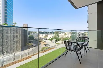 a balcony with a chair and a view of a city at Silkhaus modern 1BDR in Downtown with balcony, pool, gym in Dubai
