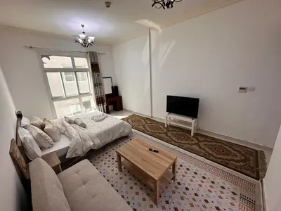 a living room with a bed and a tv at Cute Rooms and Small Partitions for Girls in Dubai- Female guests only فتيات فقط in Dubai