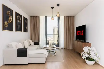 a living room with a white couch and a tv at New apt in Dubai Marina with balcony and sea view in Dubai