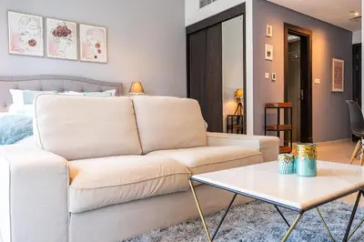 a living room with a white couch and a table at Prime Stylish Studio with Marina Views in Dubai