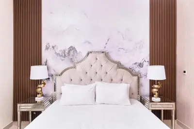 a bedroom with a large white bed with two lamps at Bellavista - Striking - 1BR with Extra Twin Room - 29 boulevard - Partial Fountain View in Dubai