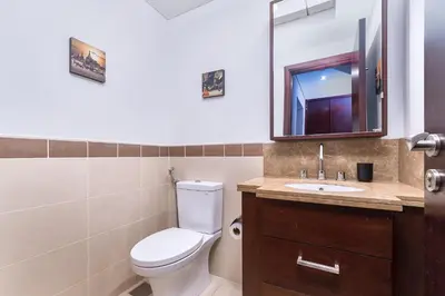 a bathroom with a toilet and a sink and a mirror at Bellavista - Striking - 1BR with Extra Twin Room - 29 boulevard - Partial Fountain View in Dubai