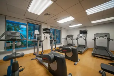 a gym with several tread machines in a room at Bellavista - Striking - 1BR with Extra Twin Room - 29 boulevard - Partial Fountain View in Dubai