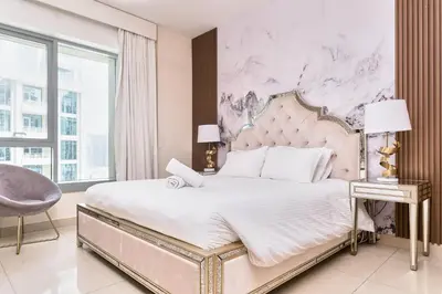a bedroom with a large bed and a marble wall at Bellavista - Striking - 1BR with Extra Twin Room - 29 boulevard - Partial Fountain View in Dubai
