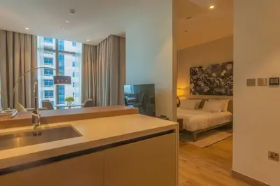 a kitchen with a sink and a living room with a bed at Maison de Luxe - Jumeirah Living Marina Gate in Dubai
