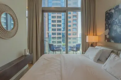a bedroom with a large white bed and a large window at Maison de Luxe - Jumeirah Living Marina Gate in Dubai