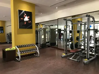 a gym with several tread machines and a picture on the wall at GuestReady - Posh Living with Burj Al Arab view in Dubai
