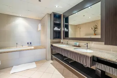 a bathroom with two sinks and a large mirror at GuestReady - Burj Al Arab view at Royal Amwaj in Dubai