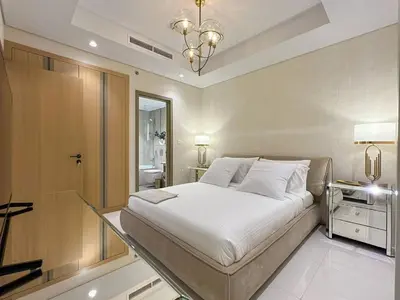 a bedroom with a large bed and a chandelier at Keyrock Living - Burj Khalifa View Retreat with Pool in Dubai