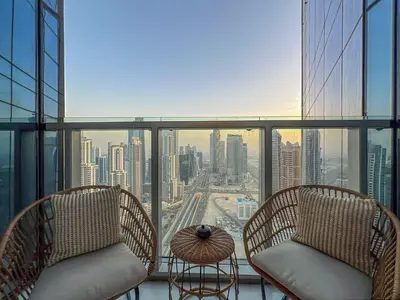 a balcony with two chairs and a table and a city at Keyrock Living - Burj Khalifa View Retreat with Pool in Dubai
