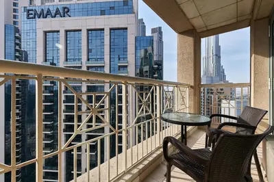 a balcony with two chairs and a table on a building at Bellavista - High Floor - 1BR - 29 Boulevard - Burj Khalifa & Fountain View in Dubai