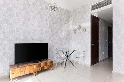 a living room with a flat screen tv on a wall at Bellavista - High Floor - 1BR - 29 Boulevard - Burj Khalifa & Fountain View in Dubai
