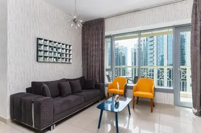 a living room with a couch and a table and chairs at Bellavista - High Floor - 1BR - 29 Boulevard - Burj Khalifa & Fountain View in Dubai
