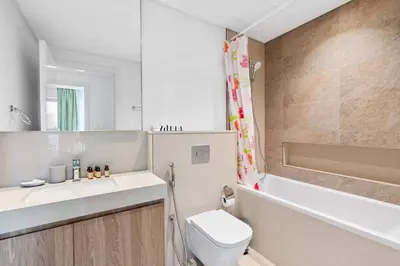 a bathroom with a toilet and a sink and a mirror at Silkhaus furnished 1BDR in Downtown new tower in Dubai