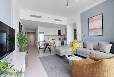 a living room with a couch and a table at Silkhaus furnished 1BDR in Downtown new tower in Dubai
