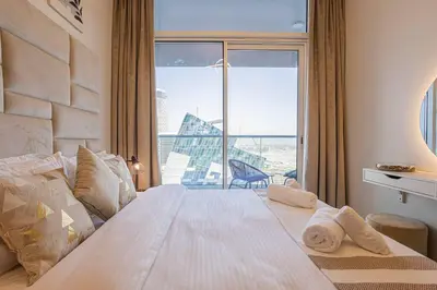 a bedroom with a large bed with a large window at AXINITE - Brand New! Warm Cozy 1 Bed HIGH FLOOR Downtown Dubai CANAL VIEW in Dubai