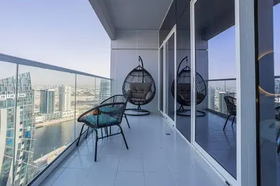 a balcony with chairs and a view of the city at AXINITE - Brand New! Warm Cozy 1 Bed HIGH FLOOR Downtown Dubai CANAL VIEW in Dubai