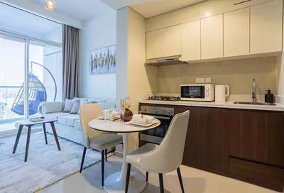 a kitchen and a living room with a table and chairs at AXINITE - Brand New! Warm Cozy 1 Bed HIGH FLOOR Downtown Dubai CANAL VIEW in Dubai