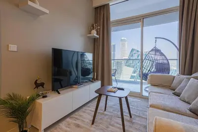 a living room with a couch and a large window at AXINITE - Brand New! Warm Cozy 1 Bed HIGH FLOOR Downtown Dubai CANAL VIEW in Dubai