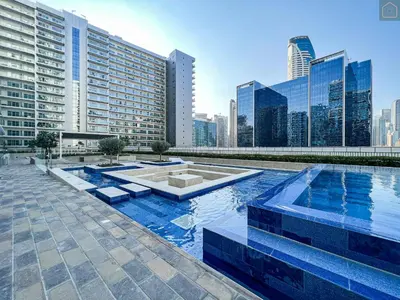 a pool in the middle of a city with tall buildings at AXINITE - Brand New! Warm Cozy 1 Bed HIGH FLOOR Downtown Dubai CANAL VIEW in Dubai