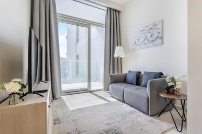 a living room with a couch and a large window at Reva Residences - One Bedroom Apartment by the S Holiday Homes in Dubai