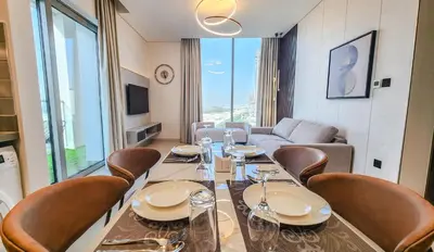 a dining room with a long table and chairs at STAY BY LATINEM Luxury 2BR Holiday Home CV B601 near Burj Khalifa in Dubai