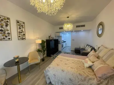 a bedroom with a large bed and a living room at Diamond Tower Marina Apartment in Dubai