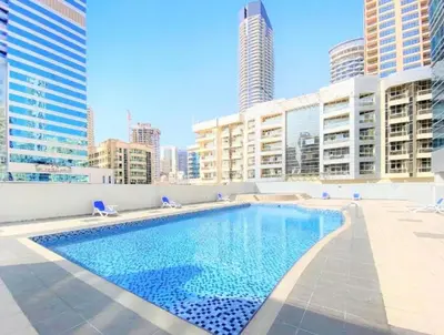 a swimming pool on the roof of a building with tall buildings at Diamond Tower Marina Apartment in Dubai