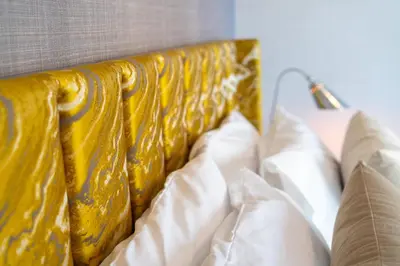 a close up of a bed with yellow sheets and pillows at Bellavista - High Floor - 1BR 29 Boulevard - Burj Khalifa & Fountain View in Dubai