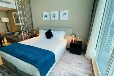 a bedroom with a large bed with a blue blanket at Canal View, Luxurious Studio In Downtown Dubai in Dubai