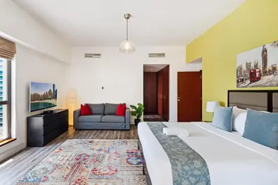 a bedroom with a large bed and a couch at La Buena Vida Holiday Homes - Deluxe, very spacious 5 Bedroom plus maidroom in Best location of JBR, Near to Beach, Marina and Tram station in Dubai