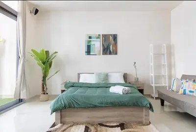 a bedroom with a bed with a green comforter at 50% OFF Summer Offert, Nice w/ Balcony & Pool View in Dubai