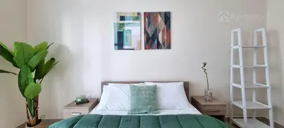 a bedroom with a bed with a green comforter at 50% OFF Summer Offert, Nice w/ Balcony & Pool View in Dubai