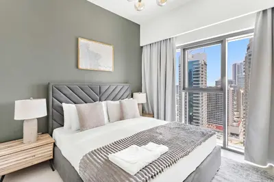 a bedroom with a large bed and a large window at Silkhaus in Burj Royale, stunning 1BR in Downtown premium tower in Dubai