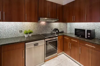 a kitchen with wooden cabinets and stainless steel appliances at Nasma Luxury Stays - Central Park Tower in Dubai