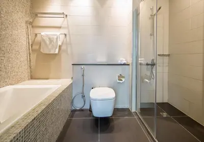 a bathroom with a toilet and a tub and a shower at Nasma Luxury Stays - Central Park Tower in Dubai