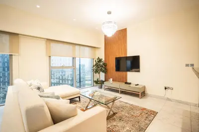 a living room with a couch and a tv at Nasma Luxury Stays - Central Park Tower in Dubai