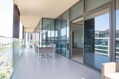 an office corridor with glass walls and a table and chairs at Nasma Luxury Stays - City Walk Building 5 in Dubai