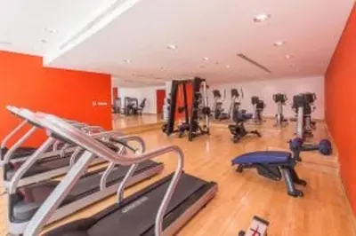 an orange gym with exercise equipment in a room at Nasma Luxury Stays - Marina-View Oasis With Balcony Steps From The Sea in Dubai