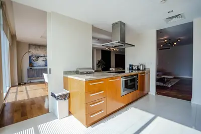 a kitchen with wooden cabinets and a stove at Nasma Luxury Stays - Limestone House in Dubai