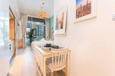 a kitchen with a table and a dining room at Cosy & Chic Studio One Marina with balcony & View in Dubai