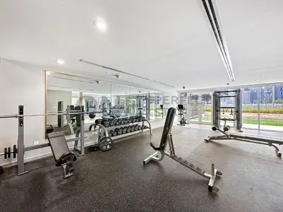 a room with a gym with two chairs and a simulator at In the heart of Business Bay - Bills included in Dubai