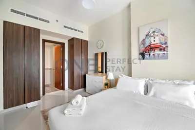 a bedroom with a large white bed with towels on it at In the heart of Business Bay - Bills included in Dubai