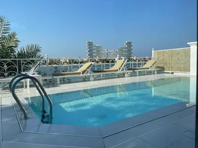 a swimming pool with lounge chairs and a swimming pool at Palm Jumeirah Beachfront private pool villa 5 BR & 1 maids room with access to beach in Dubai