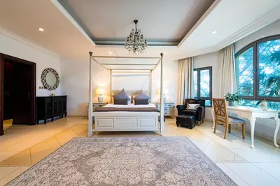 a bedroom with a canopy bed and a desk at Palm Jumeirah Beachfront private pool villa 5 BR & 1 maids room with access to beach in Dubai