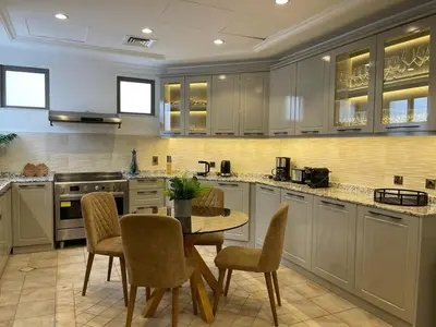 a kitchen with a table and chairs in a room at Palm Jumeirah Beachfront private pool villa 5 BR & 1 maids room with access to beach in Dubai