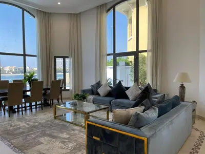 a living room with a couch and a table at Palm Jumeirah Beachfront private pool villa 5 BR & 1 maids room with access to beach in Dubai
