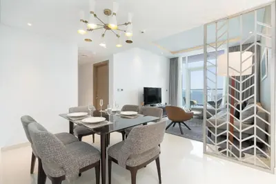 a dining room with a table and chairs and a television at Gala Guests - Maison Prive Canal View Collection in Dubai
