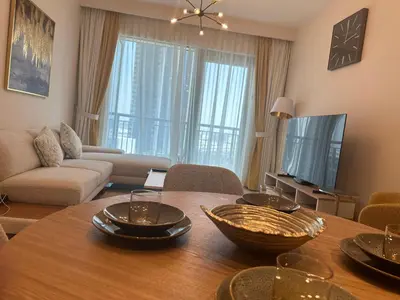 a living room with a table and a couch at ROYAL APARTMENTS DUBAI in Dubai